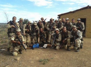 Policiais posam junto ao corpo da presa